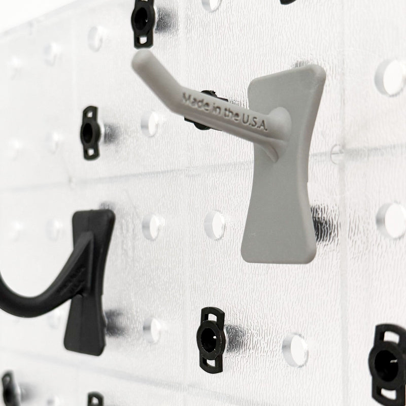 Close-up of a wall-mounted pegboard with hooks on a white background