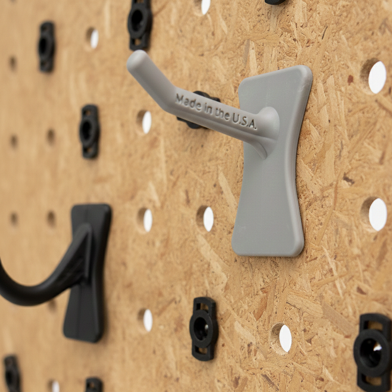 Gray and black wall hooks on a wooden pegboard with 'Made in the USA' text.